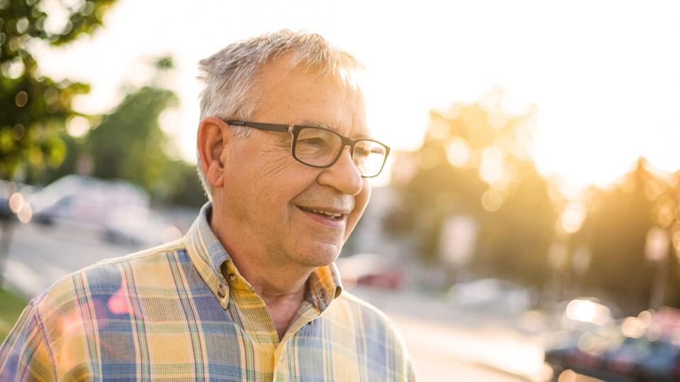 Happy older gentleman smiling in the sunshine