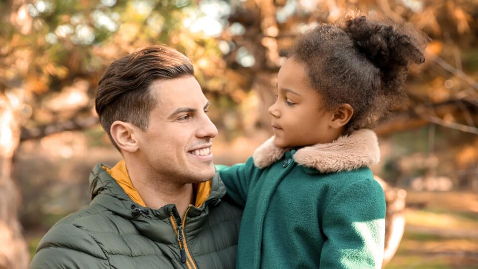 Young man and little girl outdoors on a sunny day